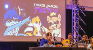 photo of a panel hosted at furdu, 3 people on the right with fursuit heads sitting on the table